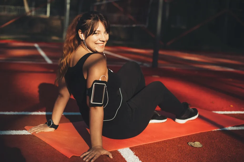 Woman sitting on yoga mat after playing a sport