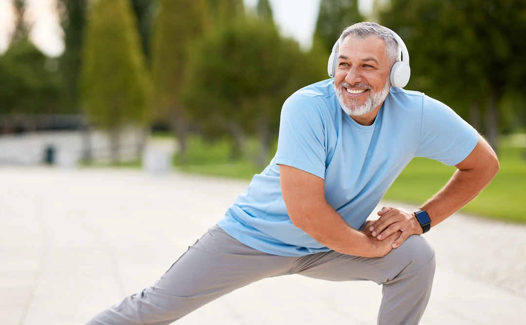 Happy mature man stretching outdoors